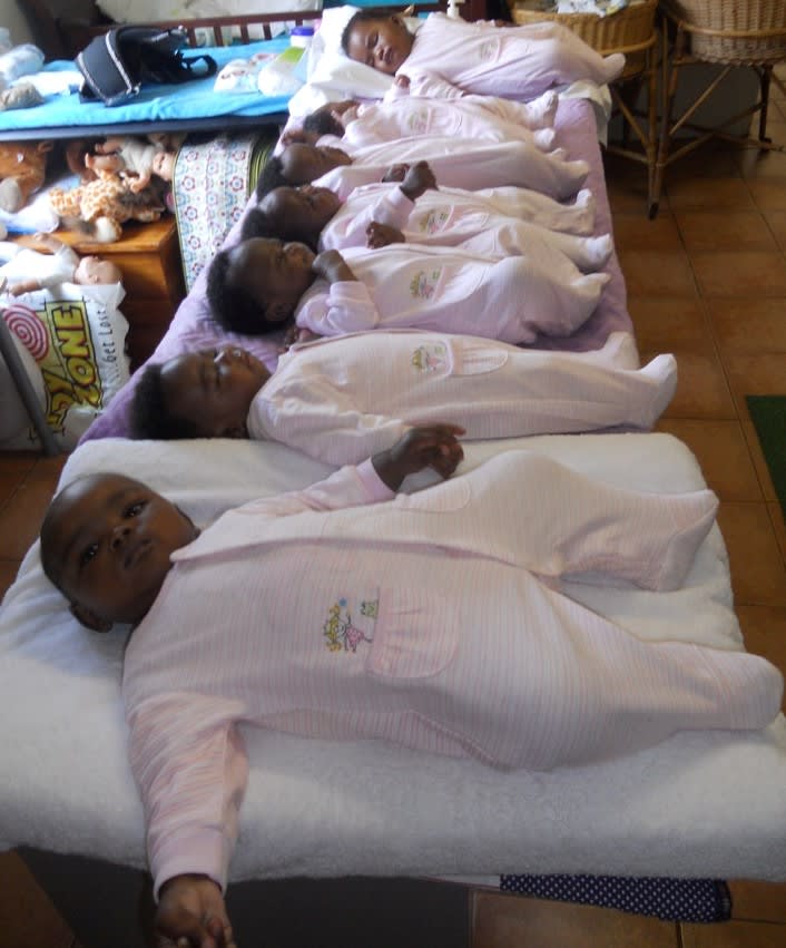 Babies in pink babygros lying in a row